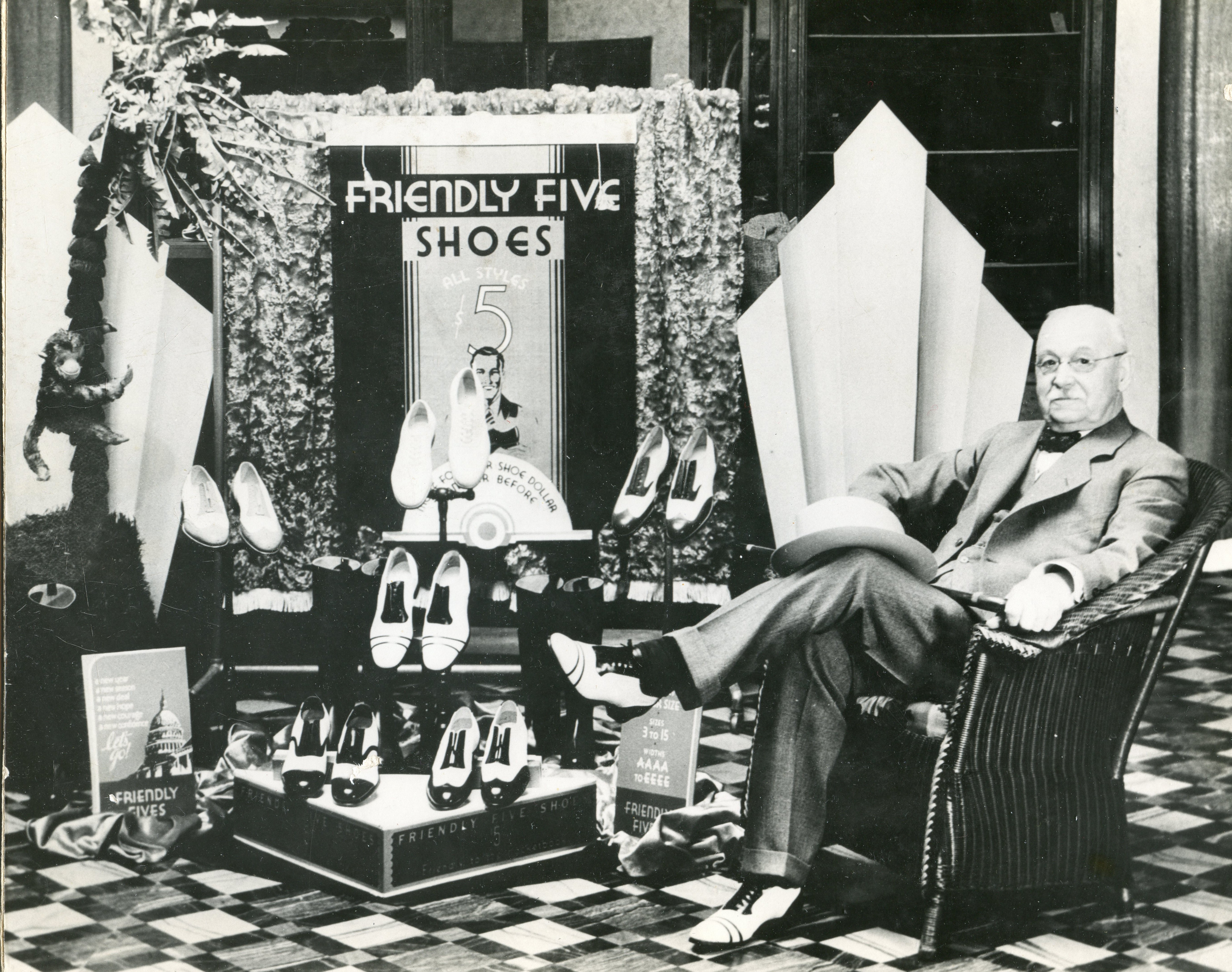 C.P. Bishop sitting in the $5 shoe display in his store.