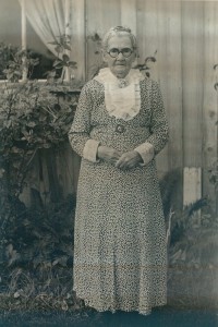 Portrait of old woman in patterned dress.
