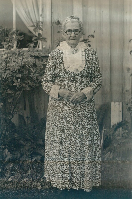 Portrait of old woman in patterned dress.